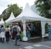 Weißes Zelt mit Ausstellungsobjekten der Biologischen Stationen und vielen Menschen.
