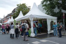 Weißes Zelt mit Ausstellungsobjekten der Biologischen Stationen und vielen Menschen.